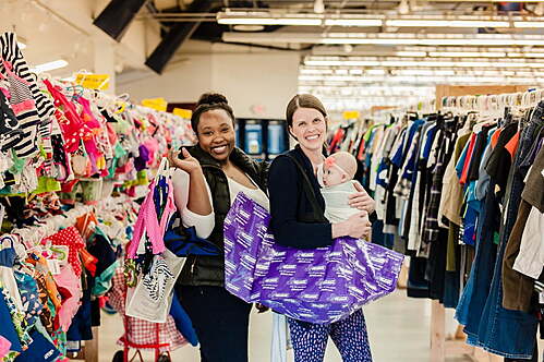 Two friends shop together—one mom wears her baby girl—as they find great deals at their local JBF sale.